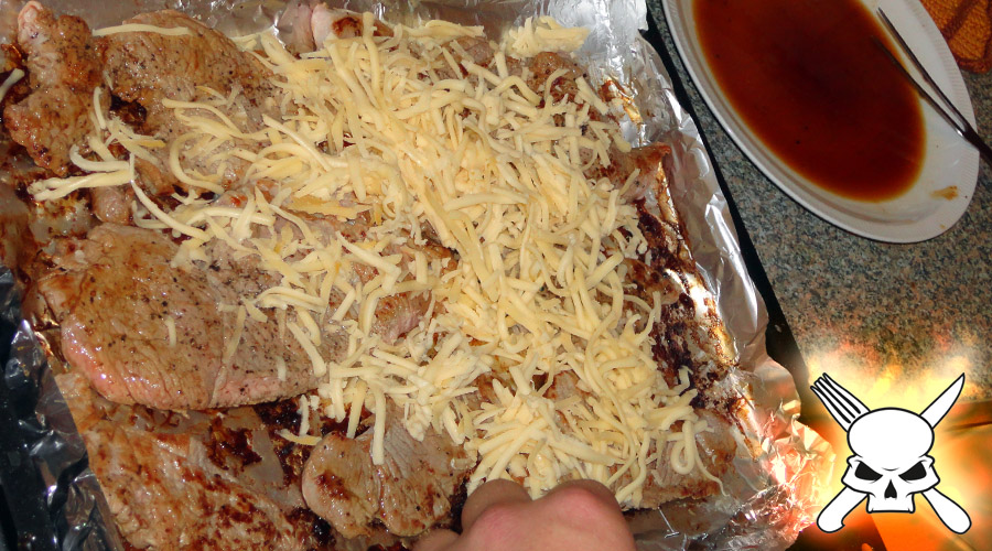Die Kalbsschnitzel kommen aufs Blech und werden im Ofen kurz mit dem geriebenen Gouda überbacken.